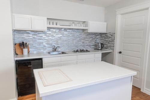 Una cocina con gabinetes blancos y una encimera blanca. en Entire Apartment in Bedford Halifax, en Halifax