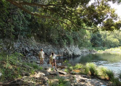 a man and a woman walking along a river at Tallaringa Views in Alstonville