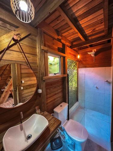 a bathroom with a sink and a toilet in a room at Pousada Vale da Magia in Praia do Rosa