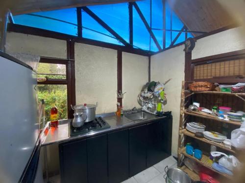 une cuisine avec un évier, une cuisinière et une fenêtre dans l'établissement Cabaña Emanuel, à Paipa