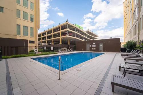 a hotel with a swimming pool in front of a building at Modern-Chic Loft in Heart of Dallas in Dallas