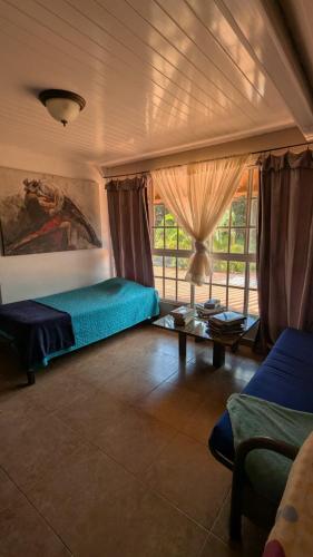 a bedroom with a bed and a couch and a table at Toucan Place in Panama City