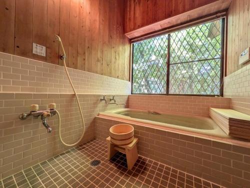 a bathroom with a tub and a toilet and a shower at Frolic Field Nasu 源泉温泉の檜風呂 一棟貸切 BBQ ドッグラン 犬OK 9名 星空テラス in Nasu