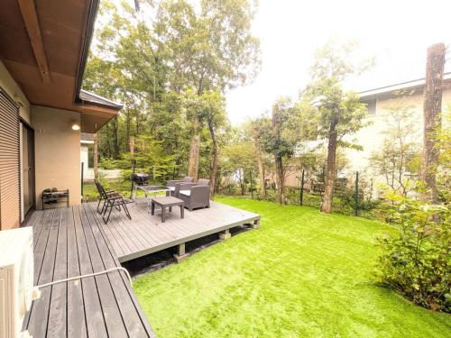 a backyard with a wooden deck with a table and chairs at Frolic Field Nasu in Nasu
