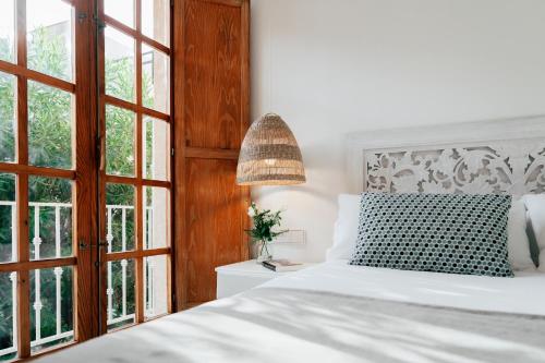 a bedroom with a white bed and a window at Valencia Living Suites in Picanya