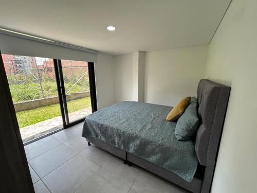 a bedroom with a bed and a large window at House 10 minutes from the airport, Rionegro in Rionegro