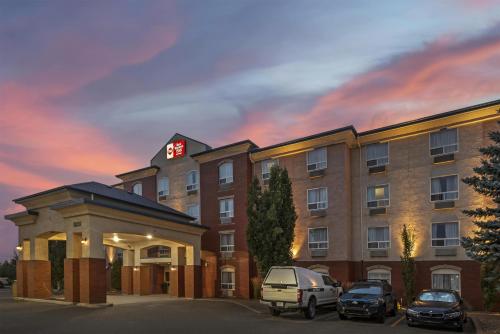 a hotel with cars parked in front of it at Best Western Plus Red Deer Inn & Suite in Red Deer