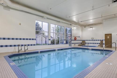 a large swimming pool with blue water in a building at Best Western Plus Red Deer Inn & Suite in Red Deer