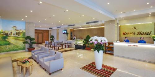 a lobby of a hotel with chairs and tables and flowers at Aristo Saigon Hotel in Ho Chi Minh City