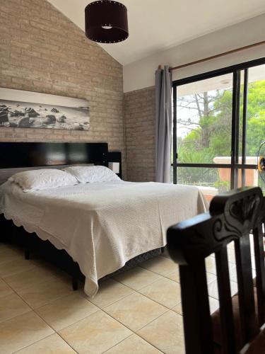 a bedroom with a bed and a large window at Apart en playa hermosa piriapolis a dos cuadras de la playa in Piriápolis