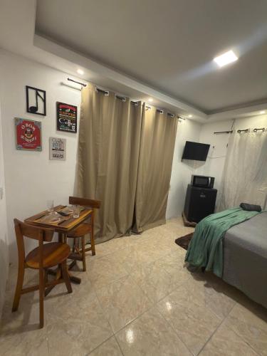 a bedroom with a table and a bed and a table and chairs at Suíte em Sitio na Pacatuba in Pacatuba