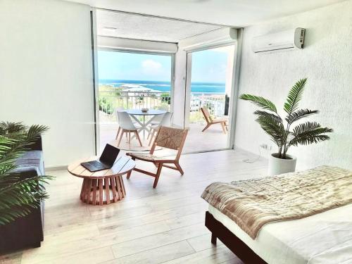 a bedroom with a bed and a table with a laptop at Breathtaking view, comfort & ideal location in Saint Martin