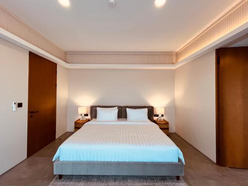 ジンバランにあるCana Villa Jimbaranの大きなベッドと2つのナイトスタンドを備えた寝室