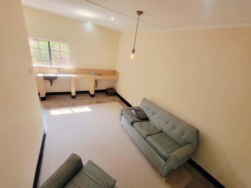 un salon avec un canapé et un bureau dans l'établissement The Silken Oak, à Kasama