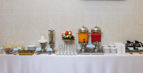 a white table with some drinks and plates on it at Aristo Saigon Hotel in Ho Chi Minh City