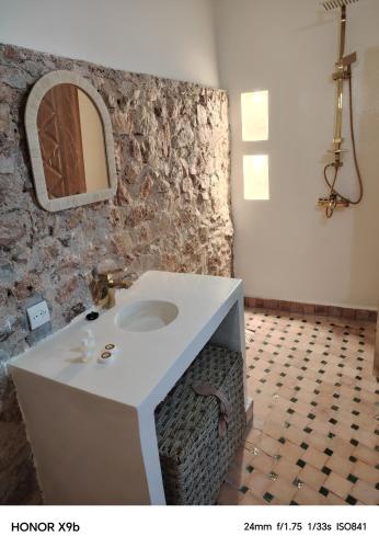 un bagno con un lavandino e un muro di pietra di Ferme d'hôtes Aghbalou a Sefrou
