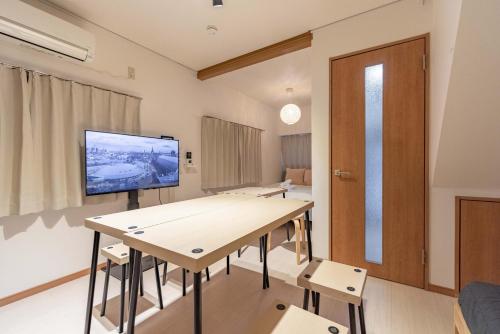 a room with a table and a tv on the wall at Lido North Shinagawa in Tokyo