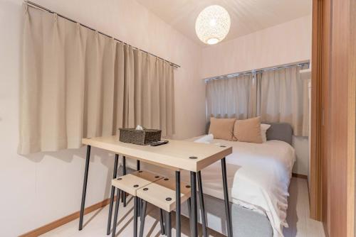 a small bedroom with a bed and a table at Lido North Shinagawa in Tokyo