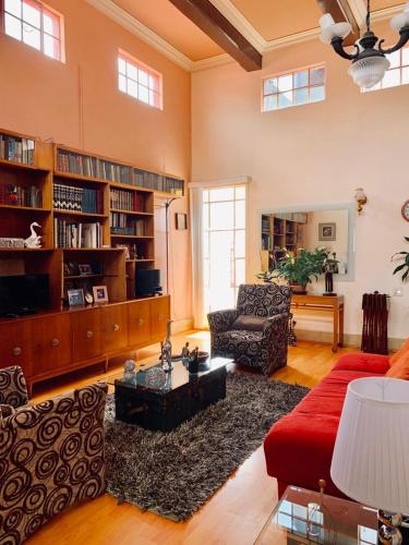 a large living room with a red couch and a red chair at Casa Luna in Mexico City