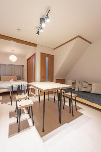 a room with tables and chairs and a bed at Lido North Shinagawa in Tokyo