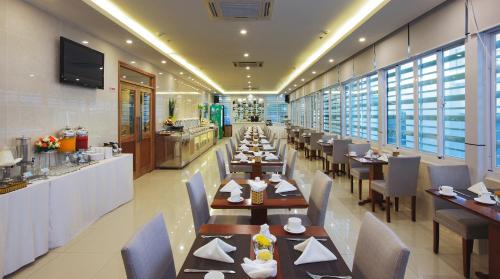 a dining room with tables and chairs in a restaurant at Aristo Saigon Hotel in Ho Chi Minh City