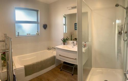 een badkamer met een bad, een wastafel en een douche bij Mapua - Rural bliss in Tasman