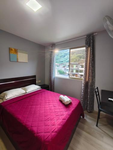 a bedroom with a large pink bed with a window at Hotel GM Double bed Zamora chinchipe in Zamora