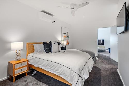 a bedroom with a large bed and a television at Stylish Coastal Retreat in Ocean Grove