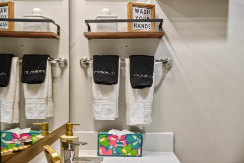 ein Badezimmer mit schwarzen und weißen Handtüchern und einem Waschbecken in der Unterkunft Stylish Vintage Loft in Dallas
