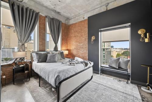 ein Schlafzimmer mit einem Bett und einer Ziegelwand in der Unterkunft Stylish Vintage Loft in Dallas