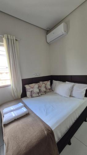 una cama grande en una habitación con ventana en AP Novo, Bem Localizado, Ar-Condicionado, en Montes Claros