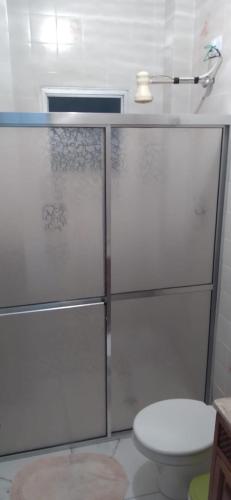 a bathroom with a glass shower with a toilet at Praia, Laser, Comércio in Praia Grande