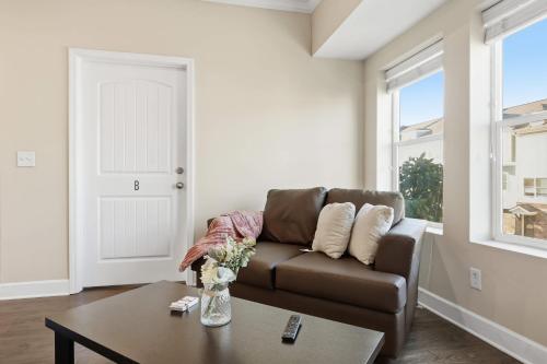 a living room with a brown couch and a table at Relax and Explore Poolside Stay Near Local Spots in Sunny Acres