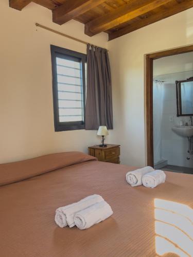 a bedroom with a bed with towels on it at Casa Isolina in Ciudad Lujan de Cuyo