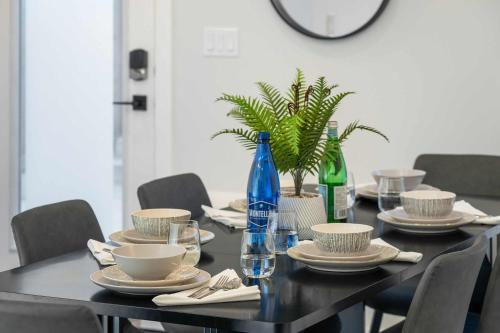 ein Esstisch mit Stühlen und einer blauen Flasche in der Unterkunft 2 in 1 Modern Retreat 4BR House Private Lower Suite in Calgary