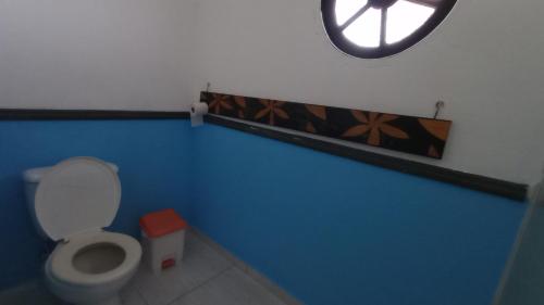 a bathroom with a toilet and a clock on the wall at Chalés na Montanha em Poços de Caldas in Poços de Caldas