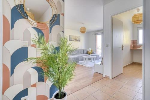 a living room with a palm plant in the middle of it at Canal de Yvette in Longjumeau