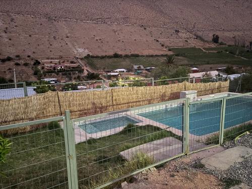 a fence next to a swimming pool with a view at Casa privada par 10 personas Horcón Valle de elqui in Horcon