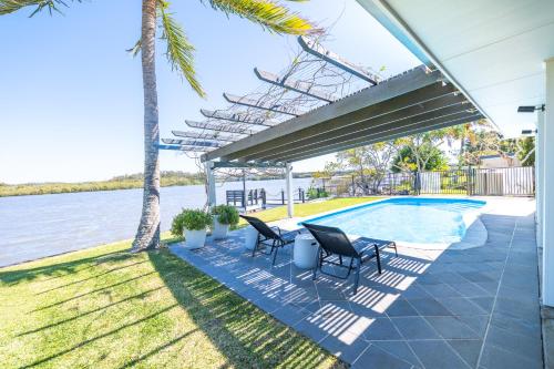 a patio with two chairs and a swimming pool at River Shack Ballina 