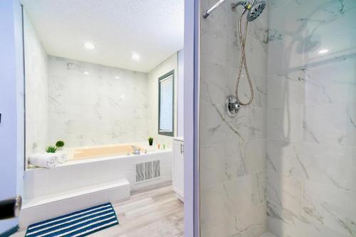 a bathroom with a tub and a shower stall at 4BD Cabin in the Poconos Near Lake with Hot Tub, Sauna, Game Room and Movie Room in East Stroudsburg