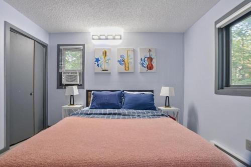 a bedroom with a large bed with blue pillows at 4BD Cabin in the Poconos Near Lake with Hot Tub, Sauna, Game Room and Movie Room in East Stroudsburg