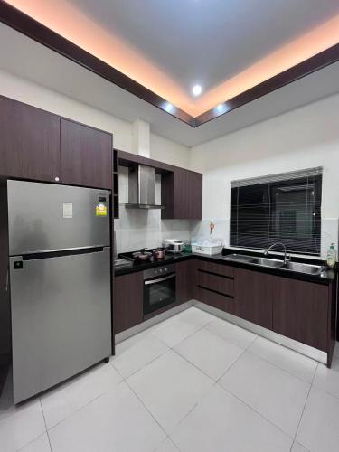 a large kitchen with a refrigerator and a sink at Dusit Garden Large Pool Villa in Na Jomtien
