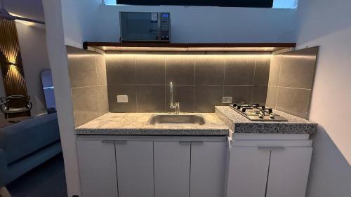 a kitchen with a sink and a stove at Maison Áurea Loft in Cali