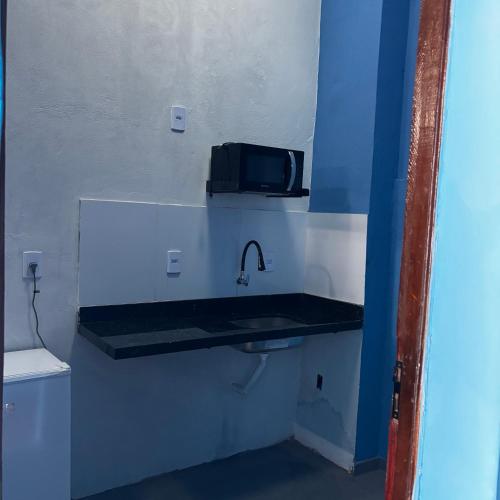 a bathroom with a sink with a microwave on the wall at Residência J&M in São Luís