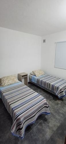 two beds sitting next to each other in a room at Los Pecos Hospedaje in Ostende