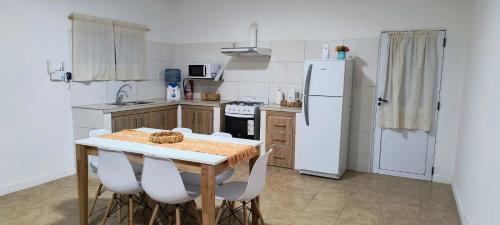 eine Küche mit einem Tisch und einem weißen Kühlschrank in der Unterkunft CasaMar in General Villegas