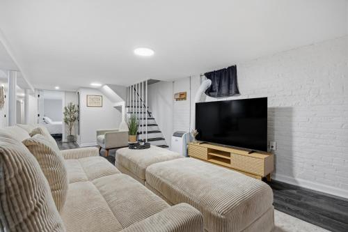 a living room with couches and a flat screen tv at Airport Haven - Cozy 2BR Apt 5 Min Away in Newark