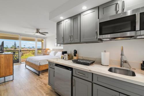 a kitchen with a sink and a bed in a room at Oceanview King Studio - Maui Banyan, Walk to Beach in Wailea