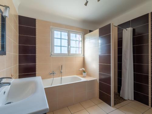 ein Badezimmer mit Badewanne und Waschbecken und einem Fenster in der Unterkunft Maison familiale à Parentis-en-Born, 6 pers. - Proche lac et plages - Ménage inclus - FR-1-319-531 in Parentis-en-Born