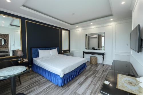 a bedroom with a bed and a table and a tv at Venus Hotel Bắc Ninh in Bắc Ninh